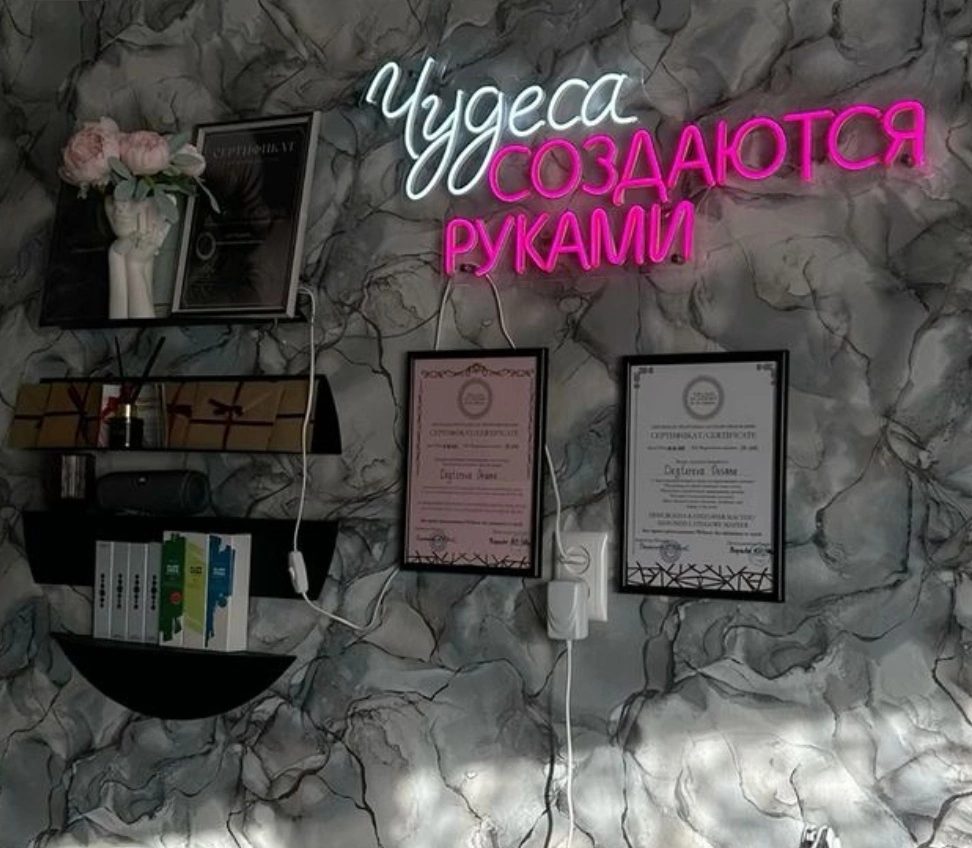 Стена кабинета с неоновой надписью «Чудеса создаются руками» и сертификатами